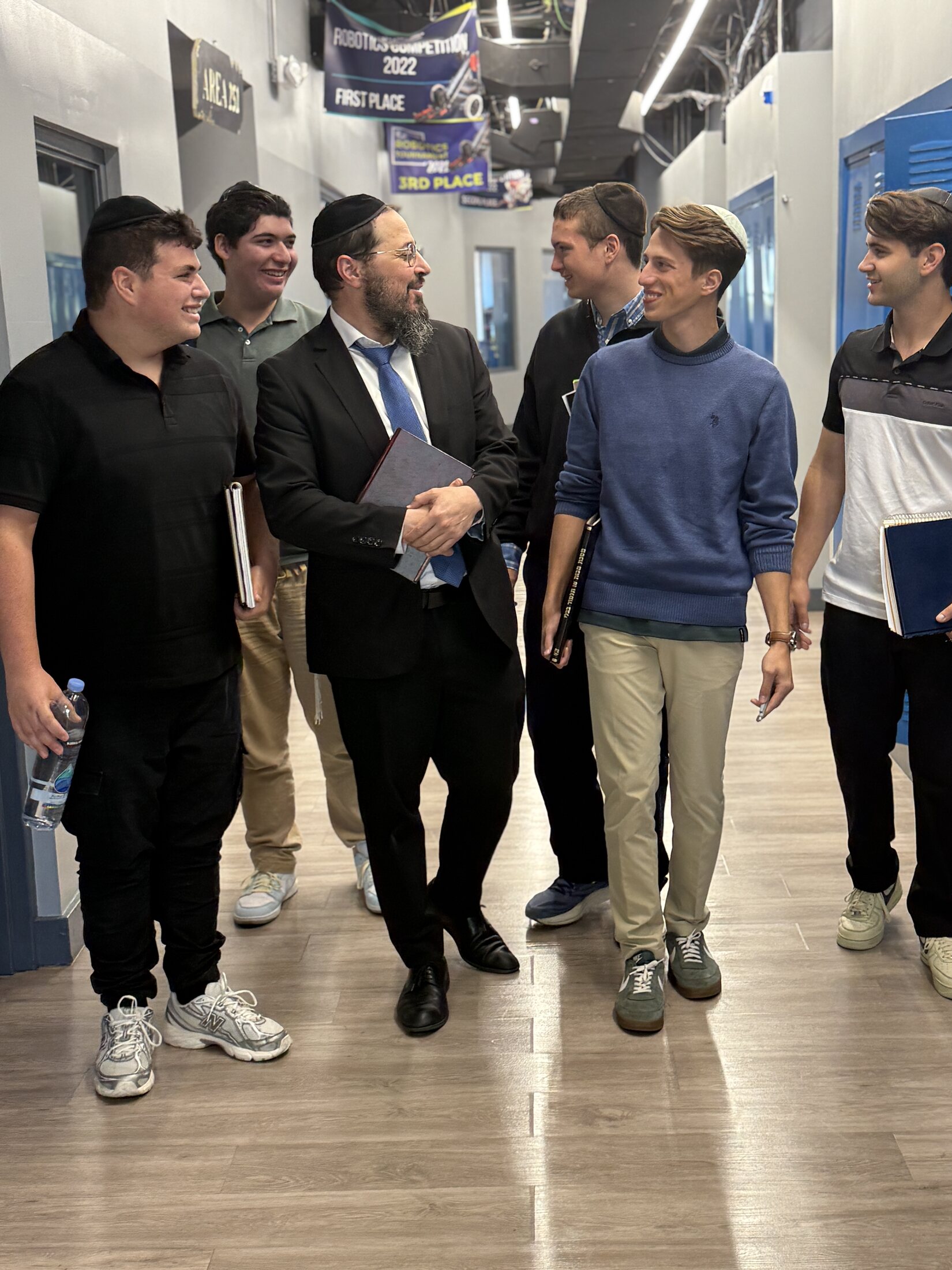 JEC students walking with a rebbe in the high school hallway